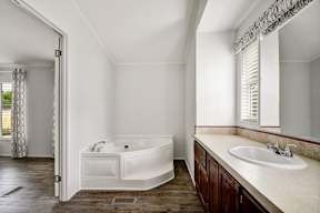 a bathroom with a bathtub and a sink at Regency Village, Texas, 78239