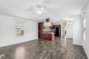 A room with a ceiling fan and wooden flooring at Country Lane, Cheyenne, Wyoming