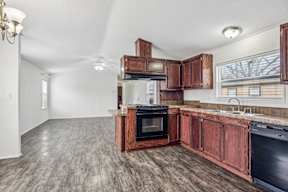 A kitchen with a black oven and wooden cabinets at Country Lane, Cheyenne, Wyoming