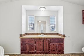 A bathroom with a wooden vanity and a large mirror at Country Lane, Cheyenne, Wyoming