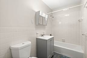 A white toilet sits next to a sink in a bathroom.