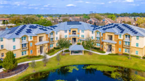 an aerial view of an apartment complex with a pond