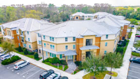 an aerial view of a large apartment complex with cars parked in the parking lot