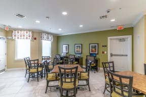 a seating area with tables and chairs at the whispering winds apartments in pearland