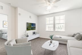 a living room with white walls and a white ceiling fan