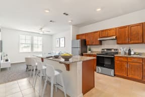 a kitchen with wooden cabinets and a large island with a granite countertop