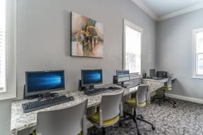a computer room with three computers and chairs