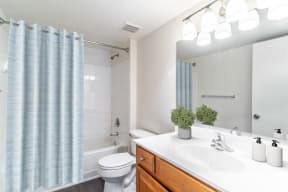 a bathroom with a white toilet next to a bathtub with a blue shower curtain