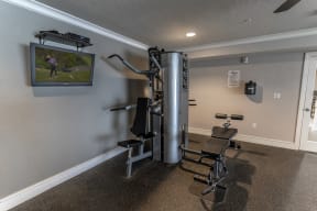 a gym with a treadmill and a tv on the wall
