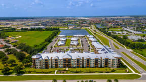 an aerial view of an apartment complex with a body of water and a city in the background