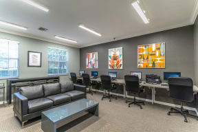 a room with a couch and a table with computers on it