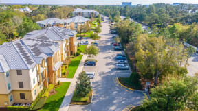 an aerial view of an apartment complex with cars parked on the side of the road