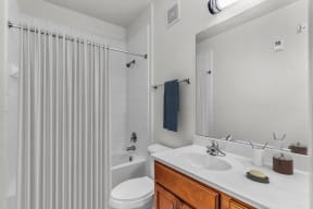 a bathroom with a white sink and tub and a white shower curtain