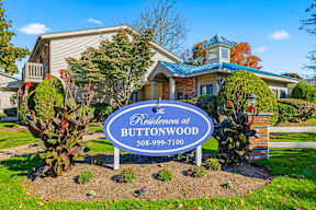 A sign for the Residences at Buttonwood with a phone number on it.
