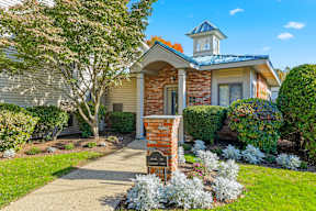 A house with a brick pillar and a mailbox in front.