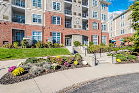 A multi-story apartment building with a landscaped front yard.