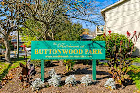 A sign for Buttonwood Park is displayed in front of a building.