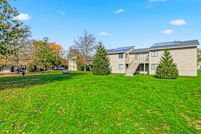 A house with a green lawn in front of it.