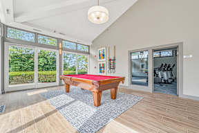 A room with a pool table and a red cloth on it.