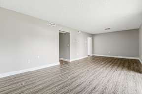A room with light grey walls and a wooden floor.