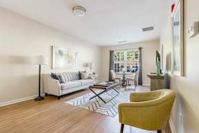 A living room with a white couch and a yellow chair.