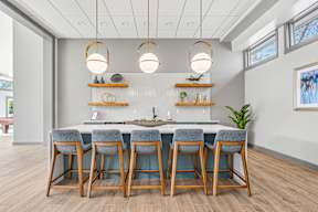 A kitchen with a bar area and chairs.