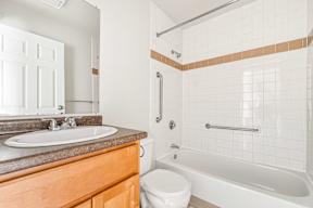 A white toilet sits next to a white sink in a bathroom.