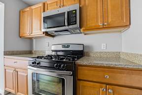 A kitchen with a stove and microwave.