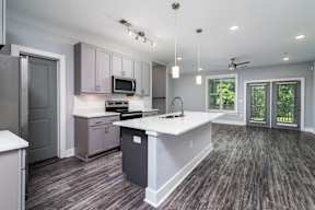 A kitchen with a white counter top and a microwave above it.