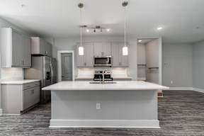 A modern kitchen with a large island and stainless steel appliances.