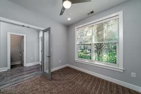A room with a window covered by white blinds.