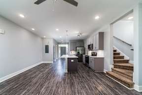 A modern kitchen with a staircase leading to the upper floor.