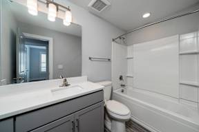 A modern bathroom with a white sink and toilet.