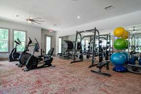 A gym with a red carpet and various exercise equipment.