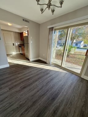 a living room with a large window and a door to a kitchen