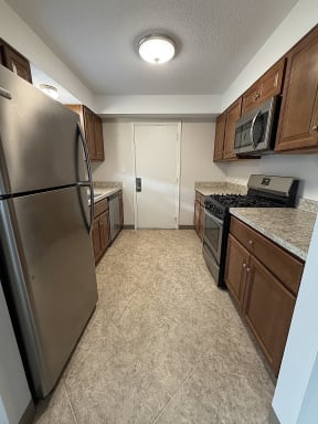 a kitchen with stainless steel appliances and wooden cabinets