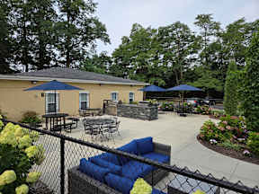 A patio area with tables and chairs and umbrellas.
