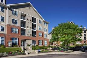 a large apartment building with stairs and a tree