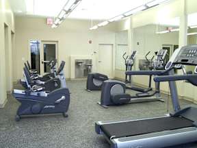 a gym with several pieces of exercise equipment in a large room