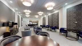 a large room with tables and chairs in a lobby