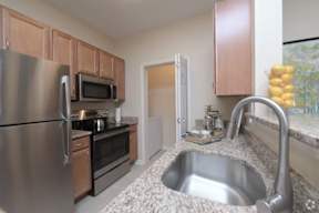 a kitchen with a stainless steel refrigerator and a sink