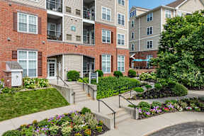 an exterior view of an apartment building with stairs and gardens