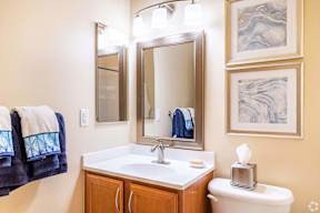a bathroom with a sink and mirrors and a toilet