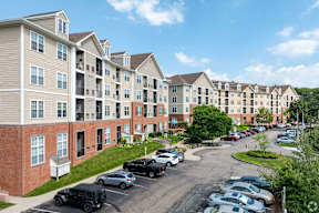 an aerial view of an apartment complex with cars parked in a parking lot