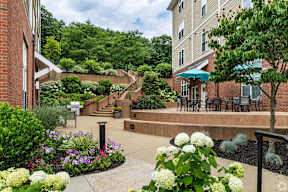 a courtyard with flowers and tables outside of a building