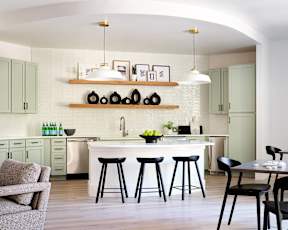 a kitchen with a white counter top and black stools
