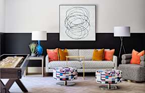 a living room with a couch and tables and a painting on the wall