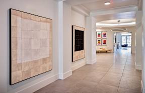 a hallway with paintings on the wall and tiled floors