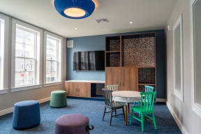a seating area with a table and chairs and a television on the wall