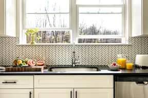 a kitchen with a sink and three windows